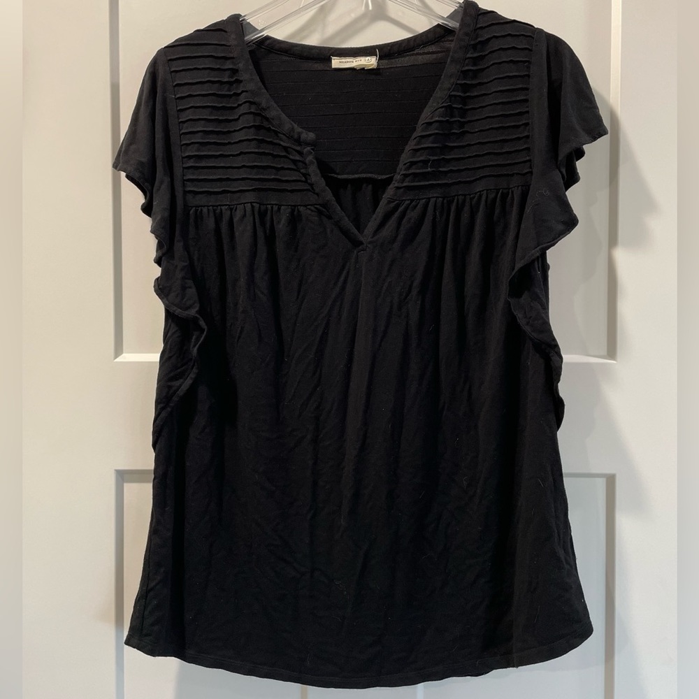 Black top with ruffle sleeves.